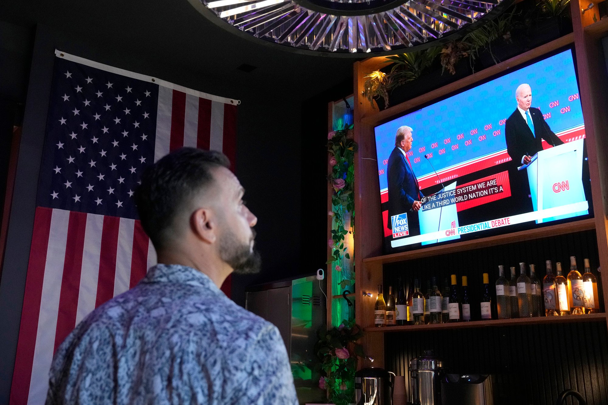 A patron watches US President Joe Biden debate Republican presidential candidate and former president Donald Trump during a debate watch party. Photo: AP